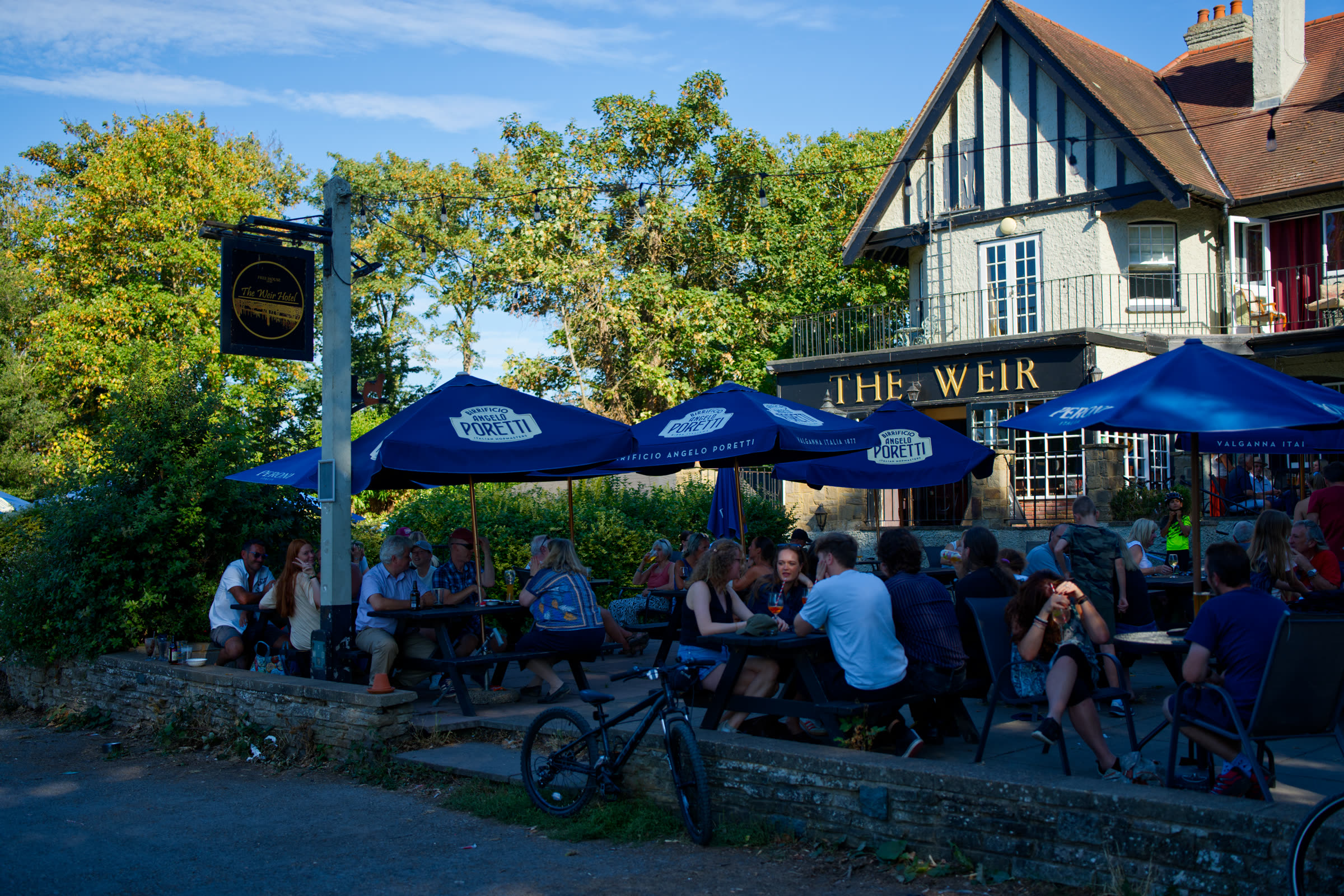 Blue parasols and packed benches on the terrace beside the venue