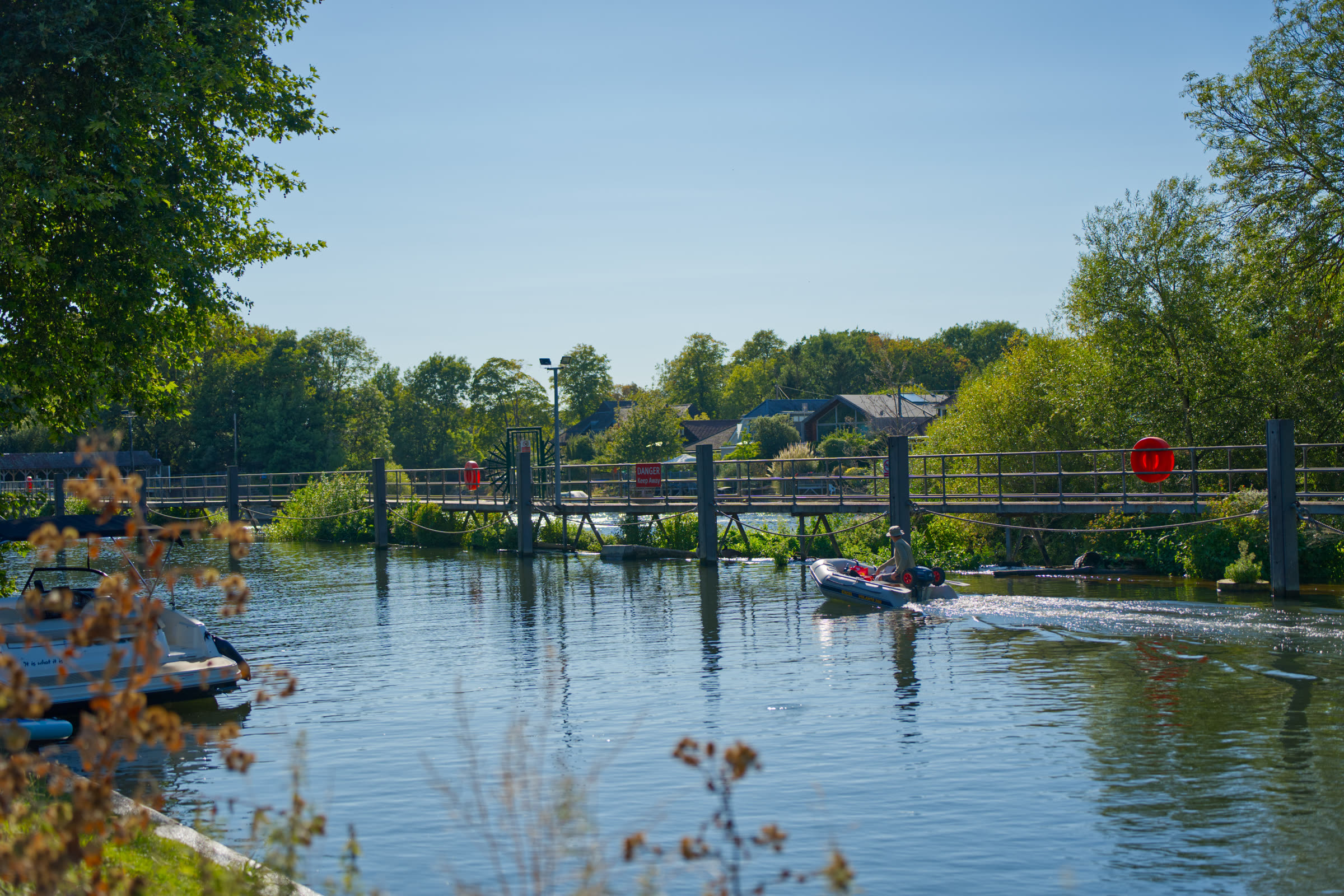 Small boat passing the footbridge on the river beside the venue