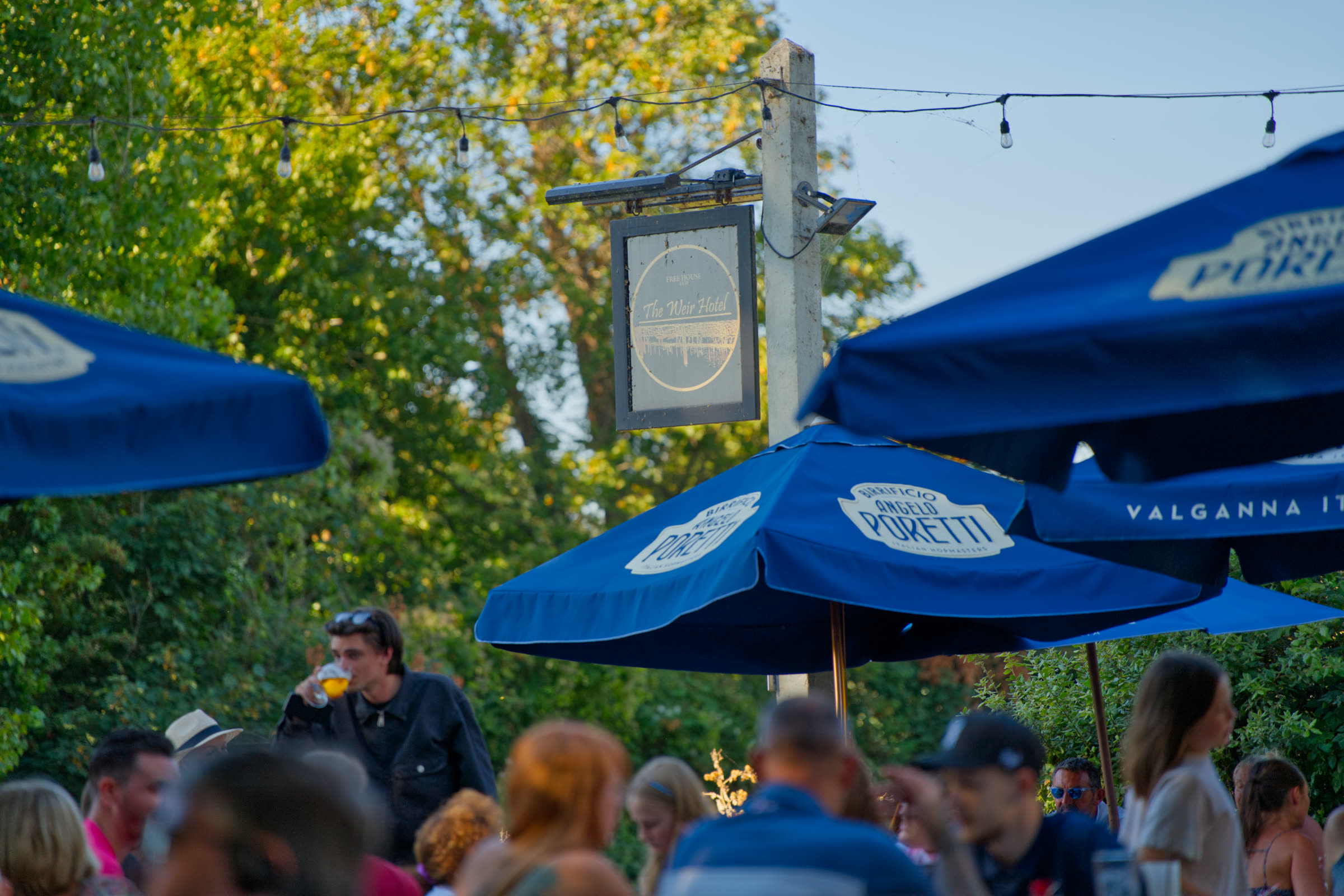 Hanging venue sign and festoon lighting above the beer garden